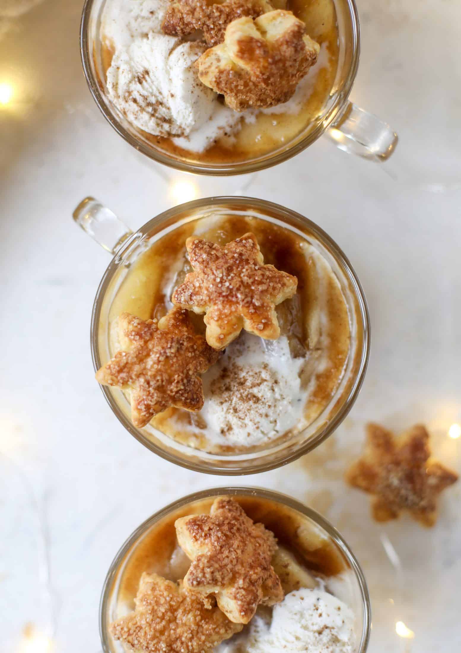This pear mug pie is the coziest way to enjoy warm, caramelized pears. Topped with vanilla ice cream and the cutest, quick puff pastry stars, these are a great dessert for a dinner party or an easy one to make for yourself on a Saturday night! I howsweeteats.com #pear #mugpie