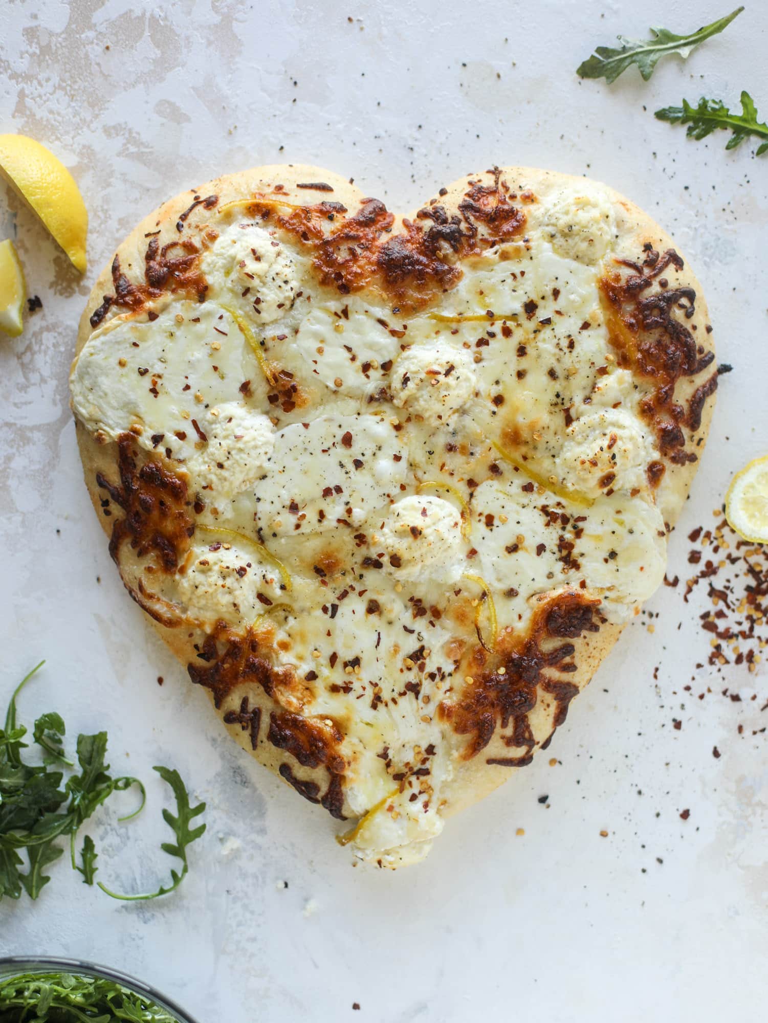 Our favorite white pizza recipe has four different kinds of cheese and comes on a garlic bread crust! Topped with crushed pepper and lemon - tons of flavor! I howsweeteats.com #white #pizza