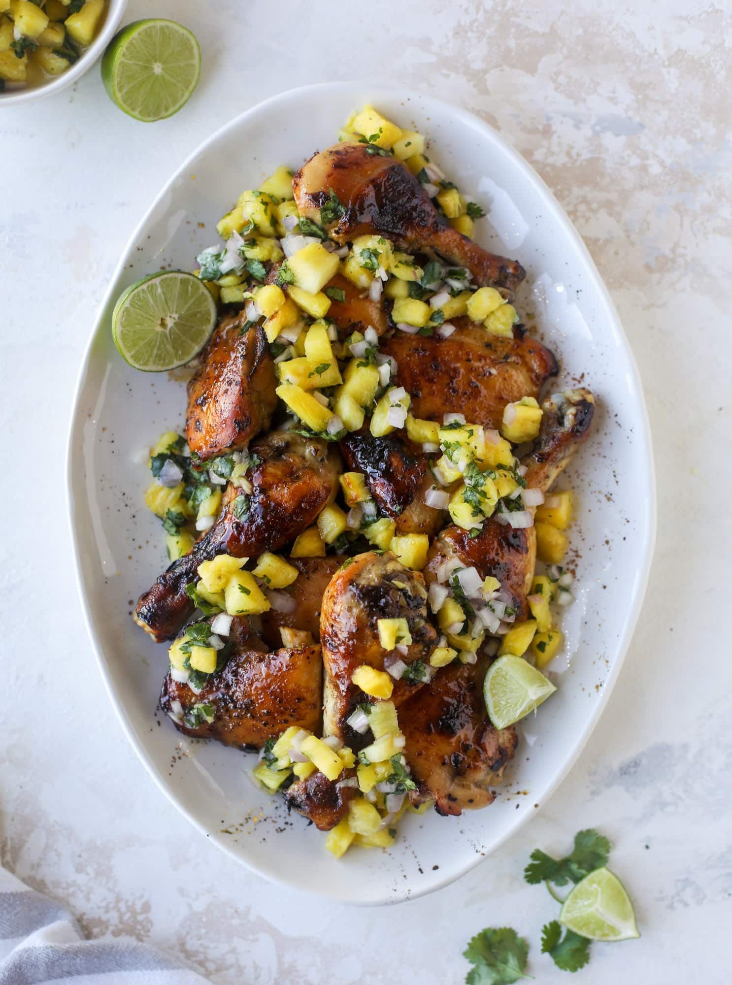 This sticky chicken recipe is made on a sheet pan and roasted until flavorfor and sticky with sauce, then served with pineapple salsa. It's the best! I howsweeteats.com #sticky #chicken