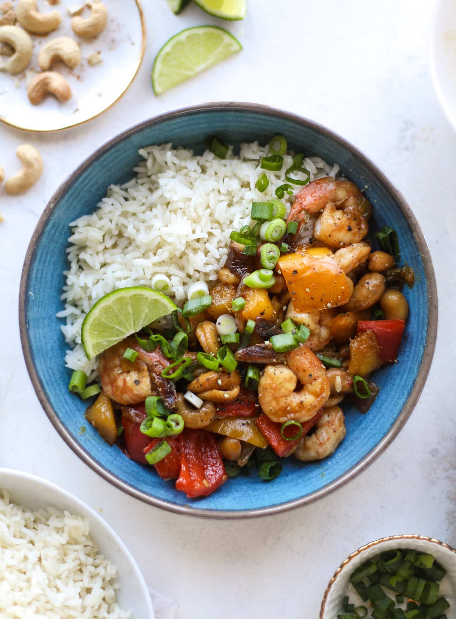 This cashew shrimp stir fry is a super simple weeknight meal! Made with bell peppers and mango, it is delicious over rice and comes together in 25 minutes. I howsweeteats.com #cashew #shrimp
