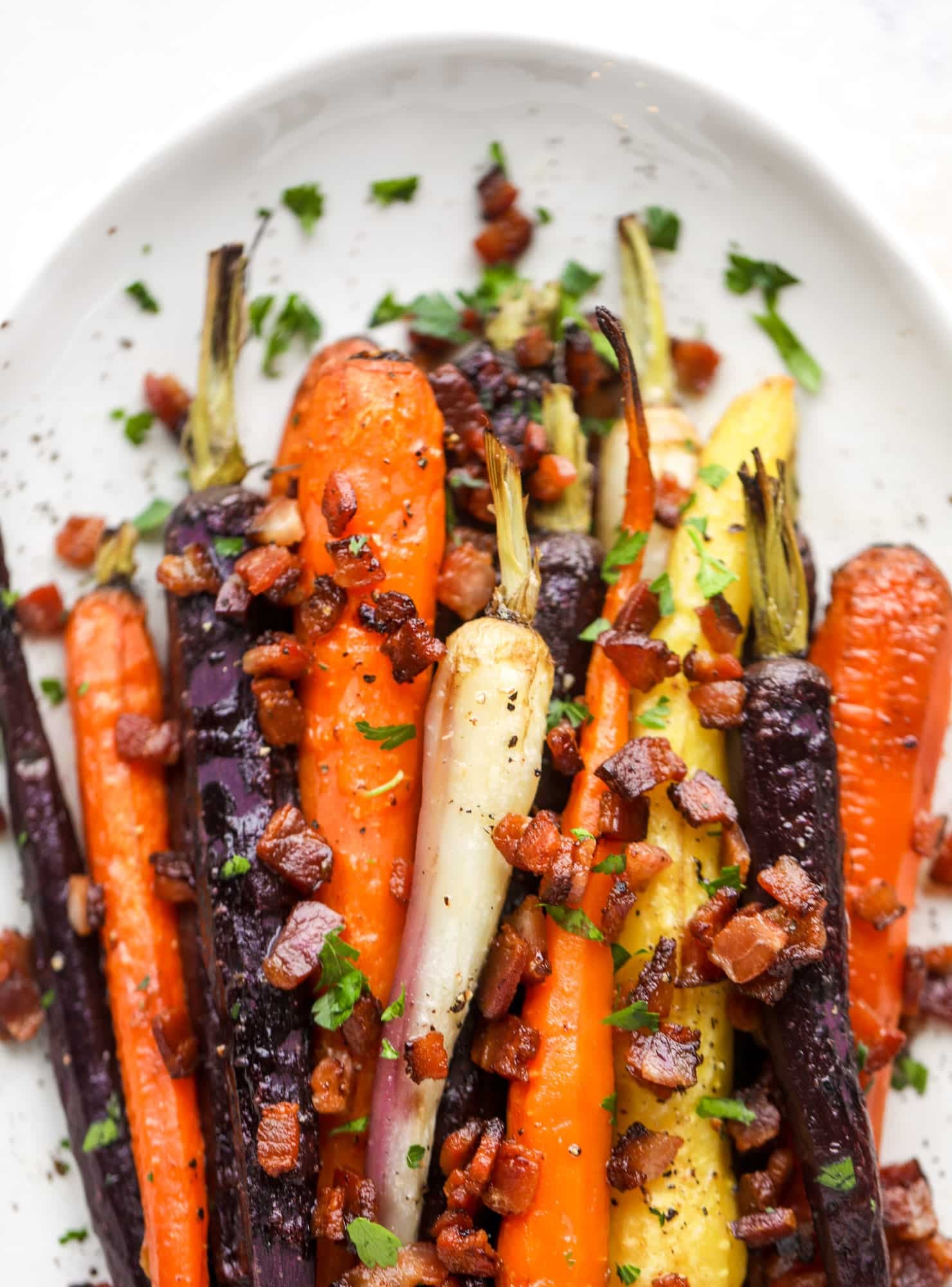 Sweet carrots are drizzled with bacon fat and chopped bacon, then roasted until they are tender, sweet and caramely. So much flavor!