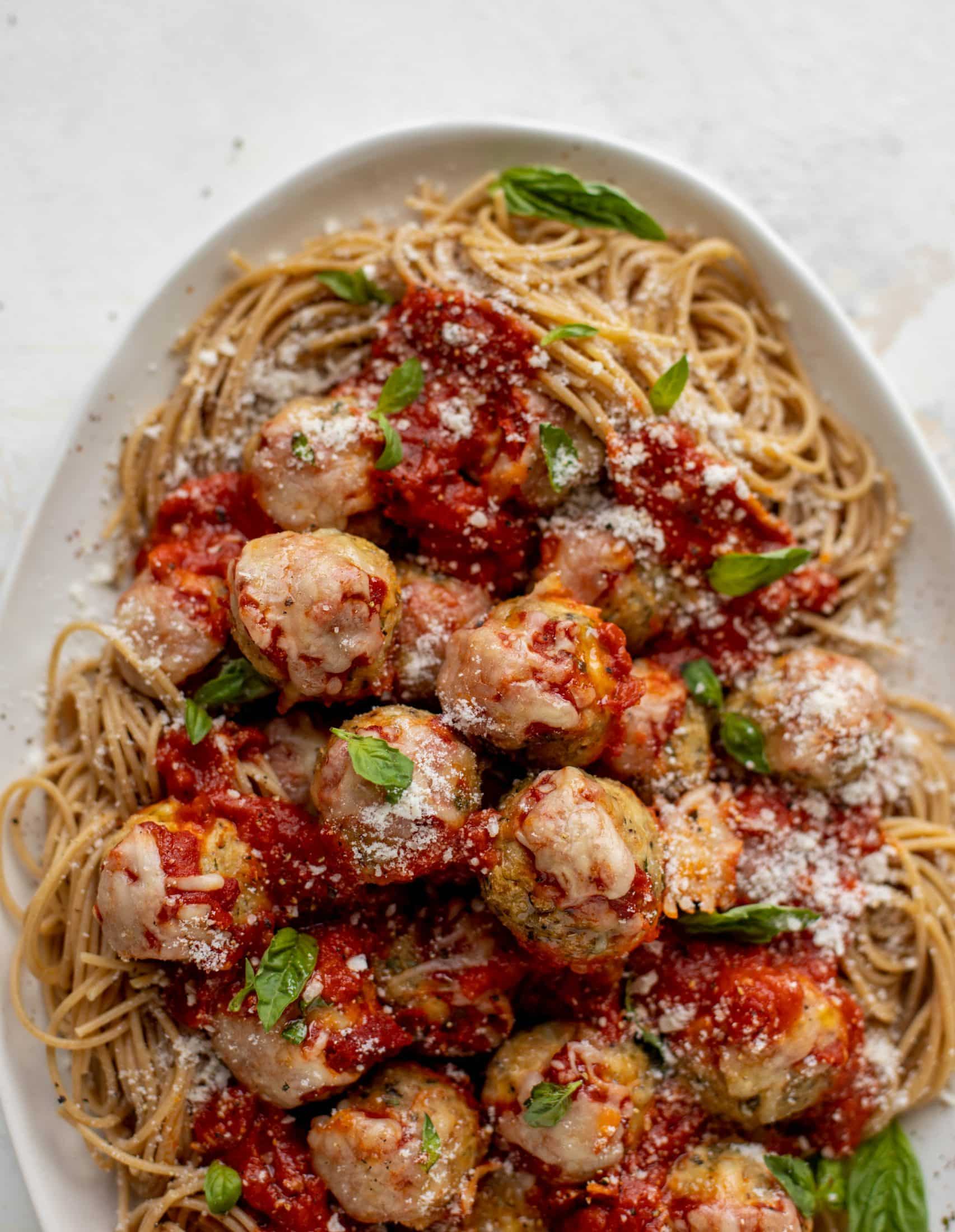 Chicken parmesan meatballs are baked and super flavorful! Serve with roasted garlic spaghetti for the best dinner ever! You can make them ahead of time too!