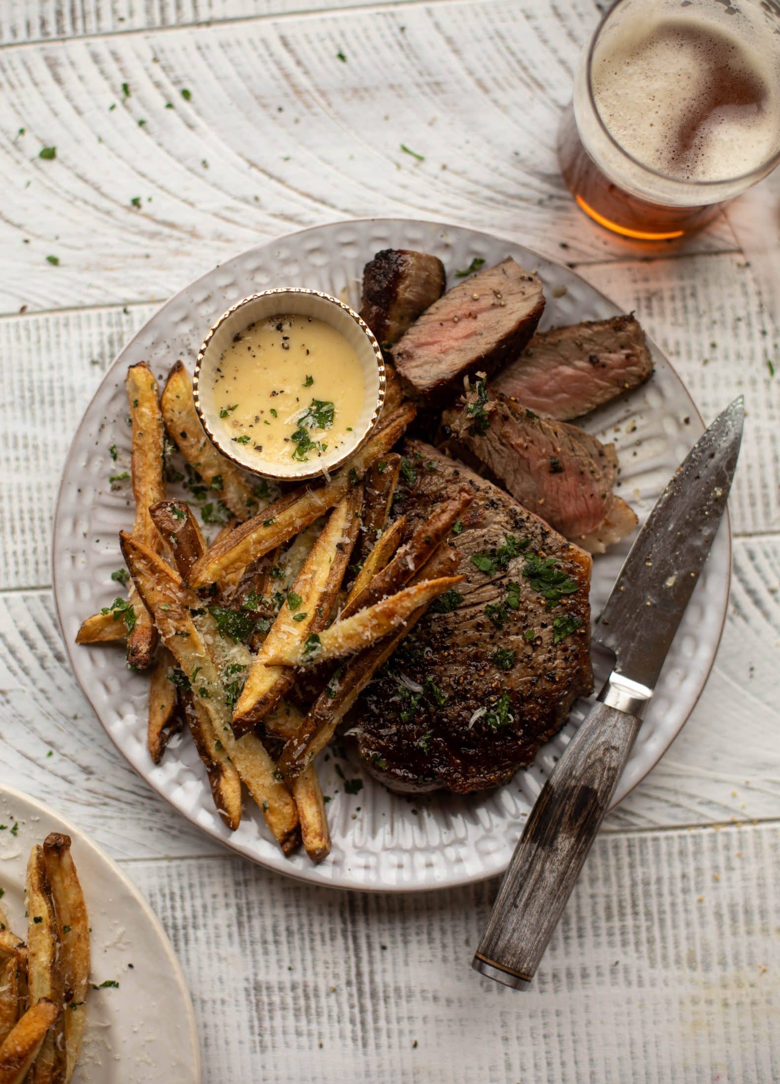 This is our favorite steak frites! Seared skillet steak and crispy fries made in the air fryer, topped with truffle salt, parmesan and herbs!