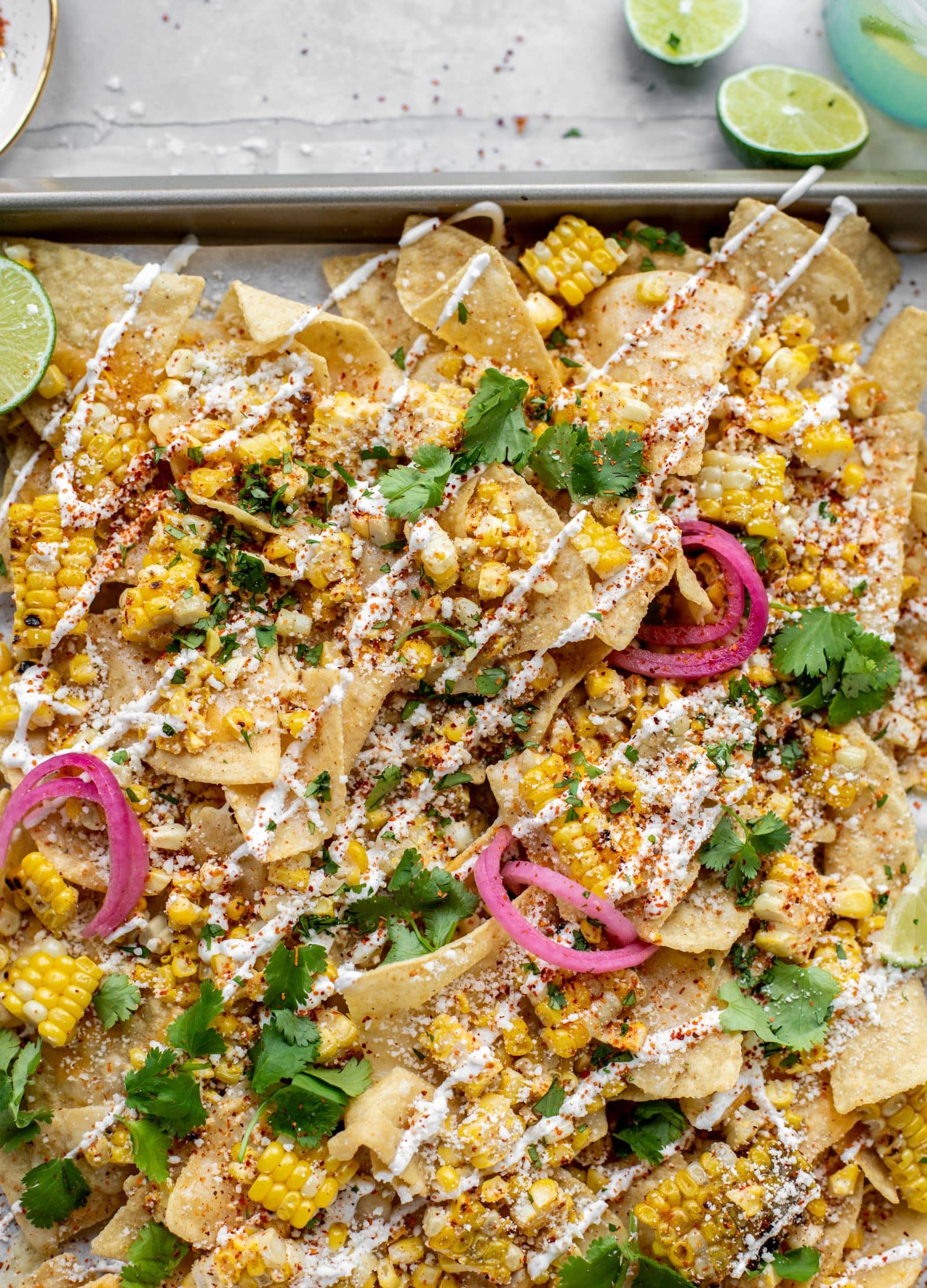 These sheet pan street corn nachos are ridiculously easy and delicious! Grilled corn, chili, lime, tons of cheese and all the flavor you could dream of!