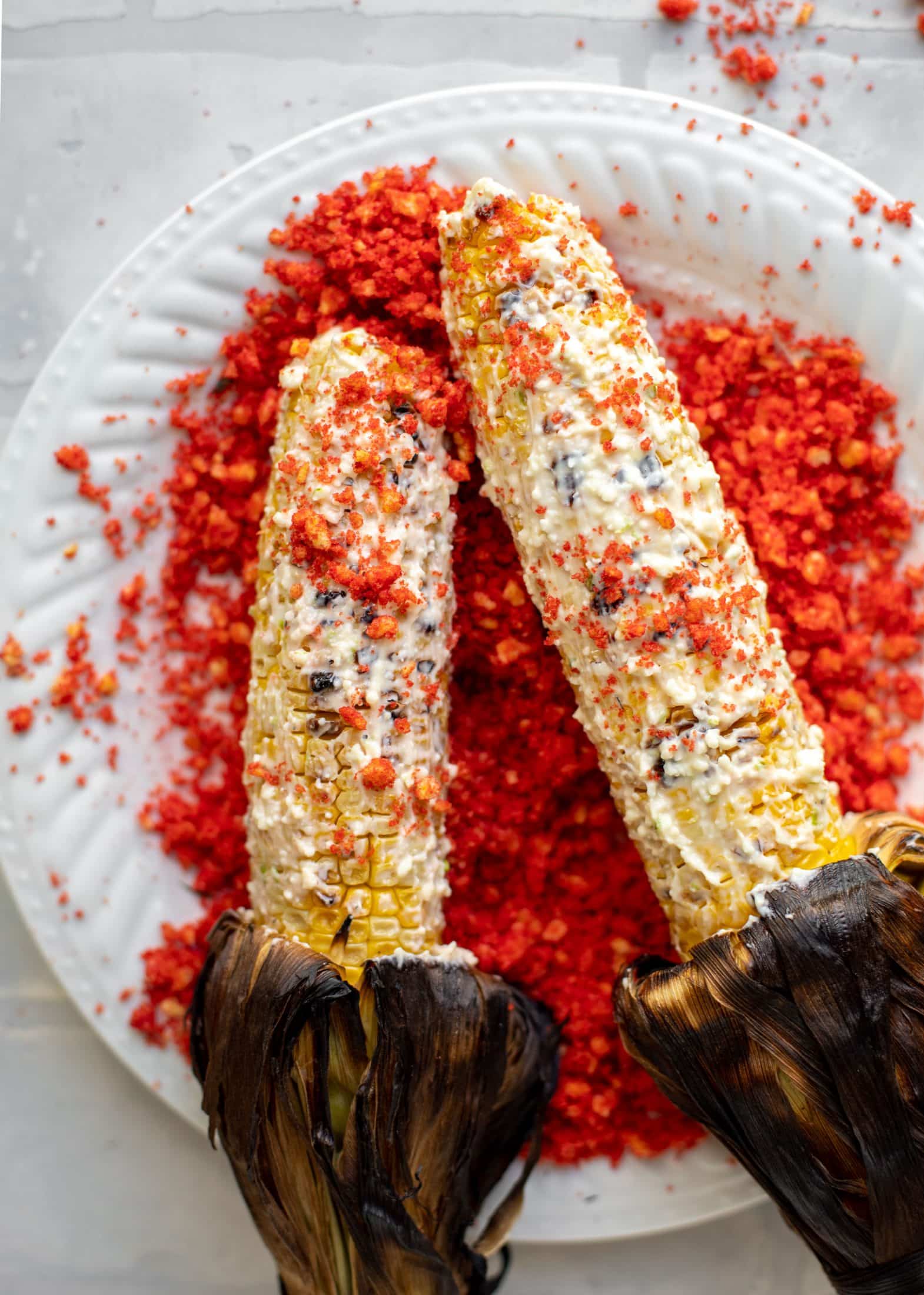 rolling corn on the cob in cotija mayo