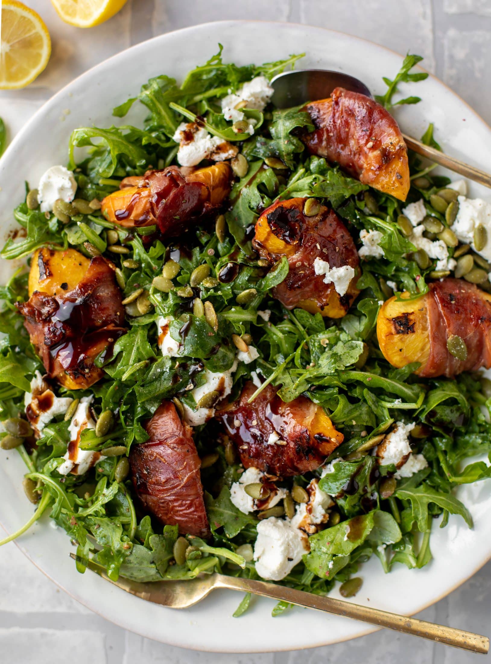 grilled prosciutto wrapped peaches with arugula and goat cheese