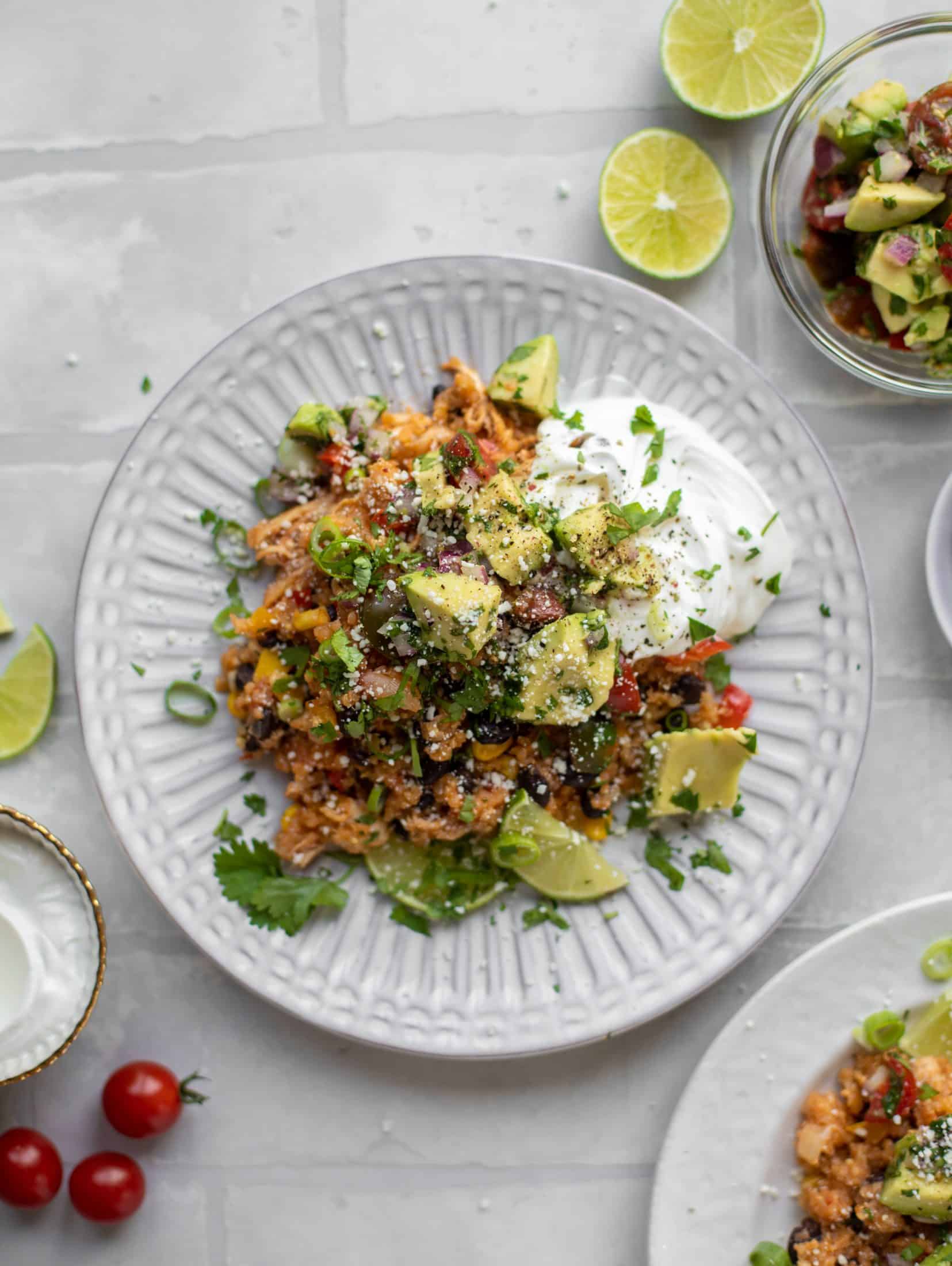 one pot salsa chicken quinoa topped with avocado pico de gallo and sour cream