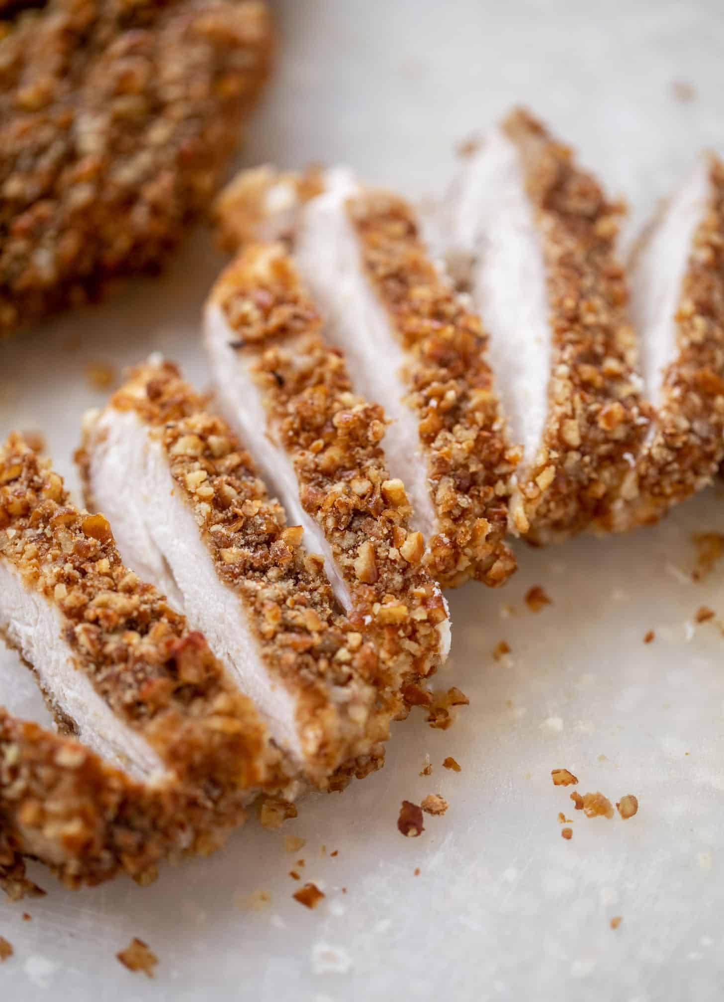 sliced pretzel crusted chicken on cutting board