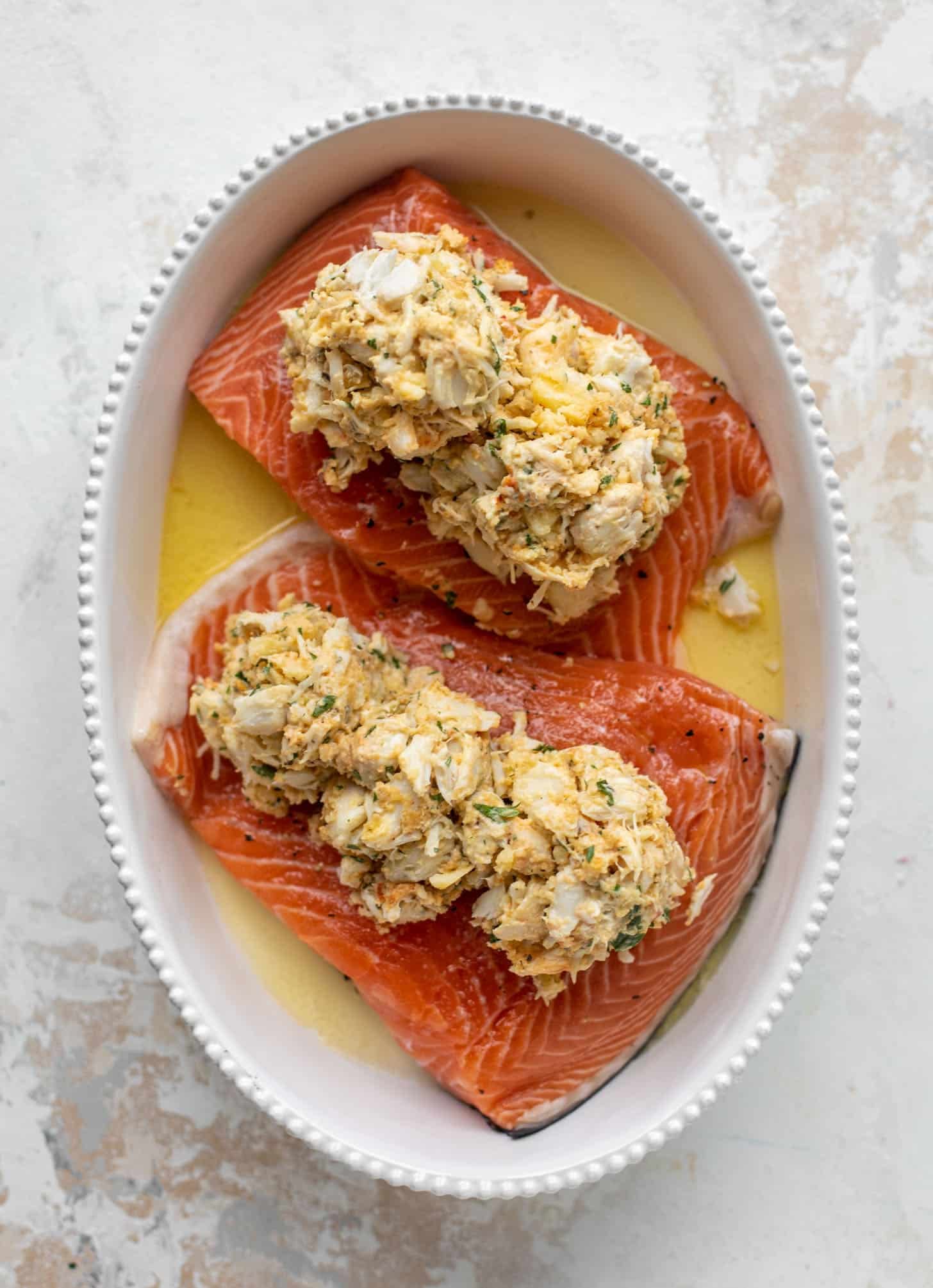 salmon in a baking dish topped with crabmeat