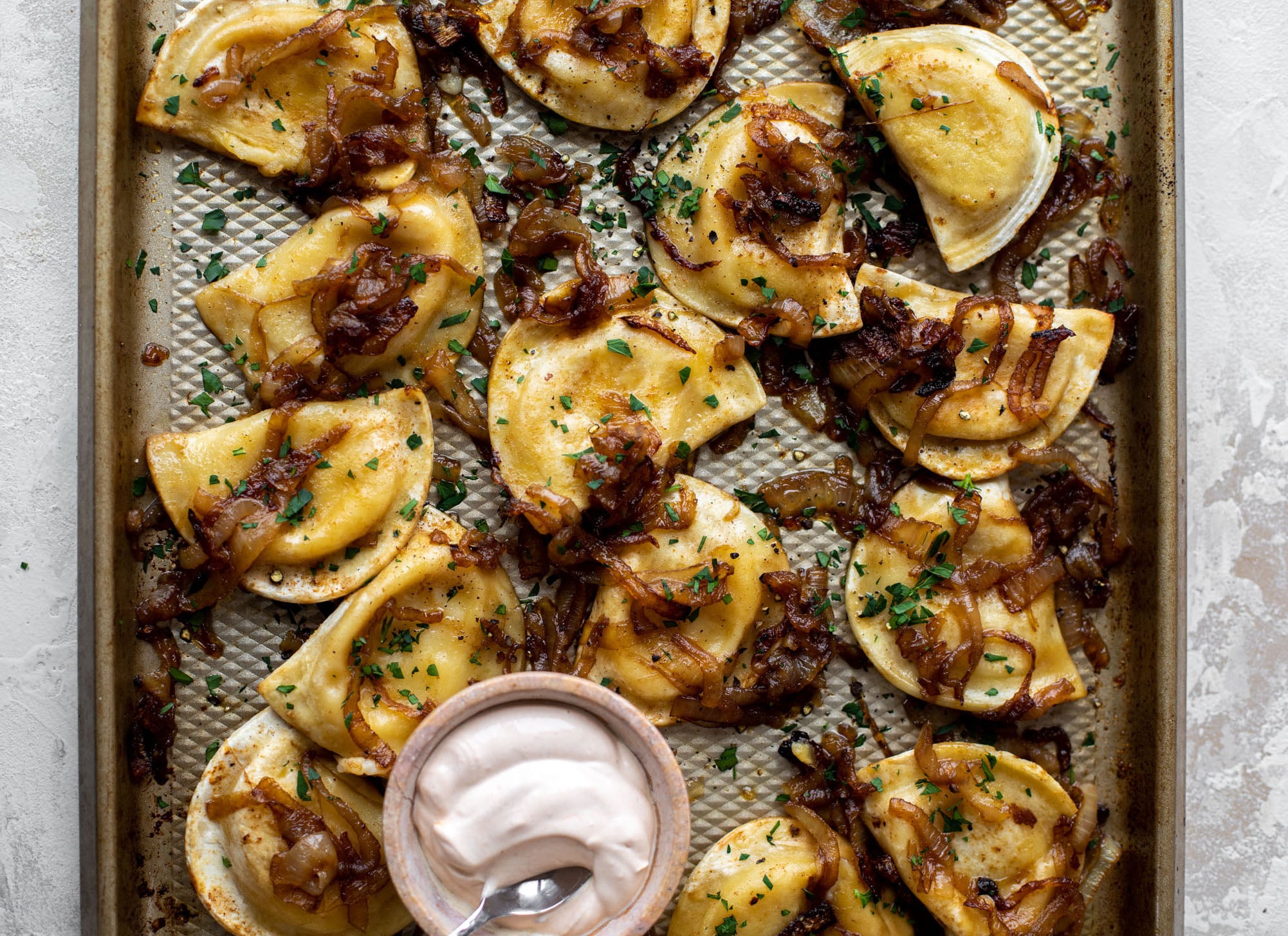 sheet pan pierogies with caramelized onions and chipotle sour cream