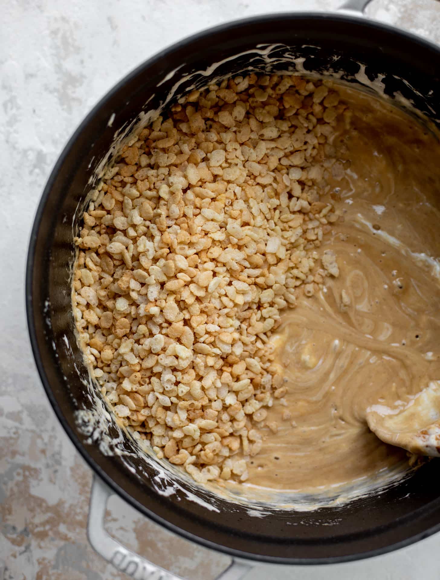 stirring the rice cereal into the peanut butter marshmallow