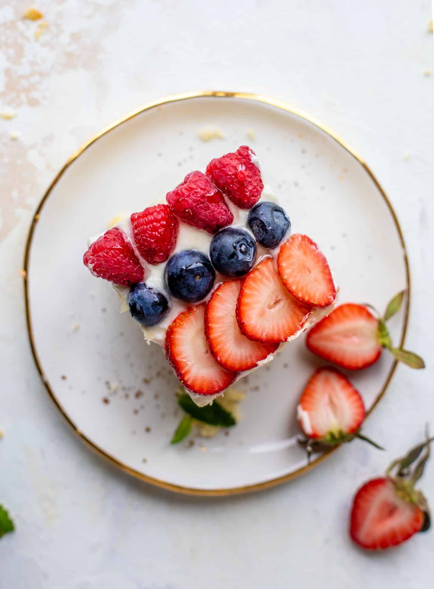 slice of triple berry sheet cake with cream cheese frosting