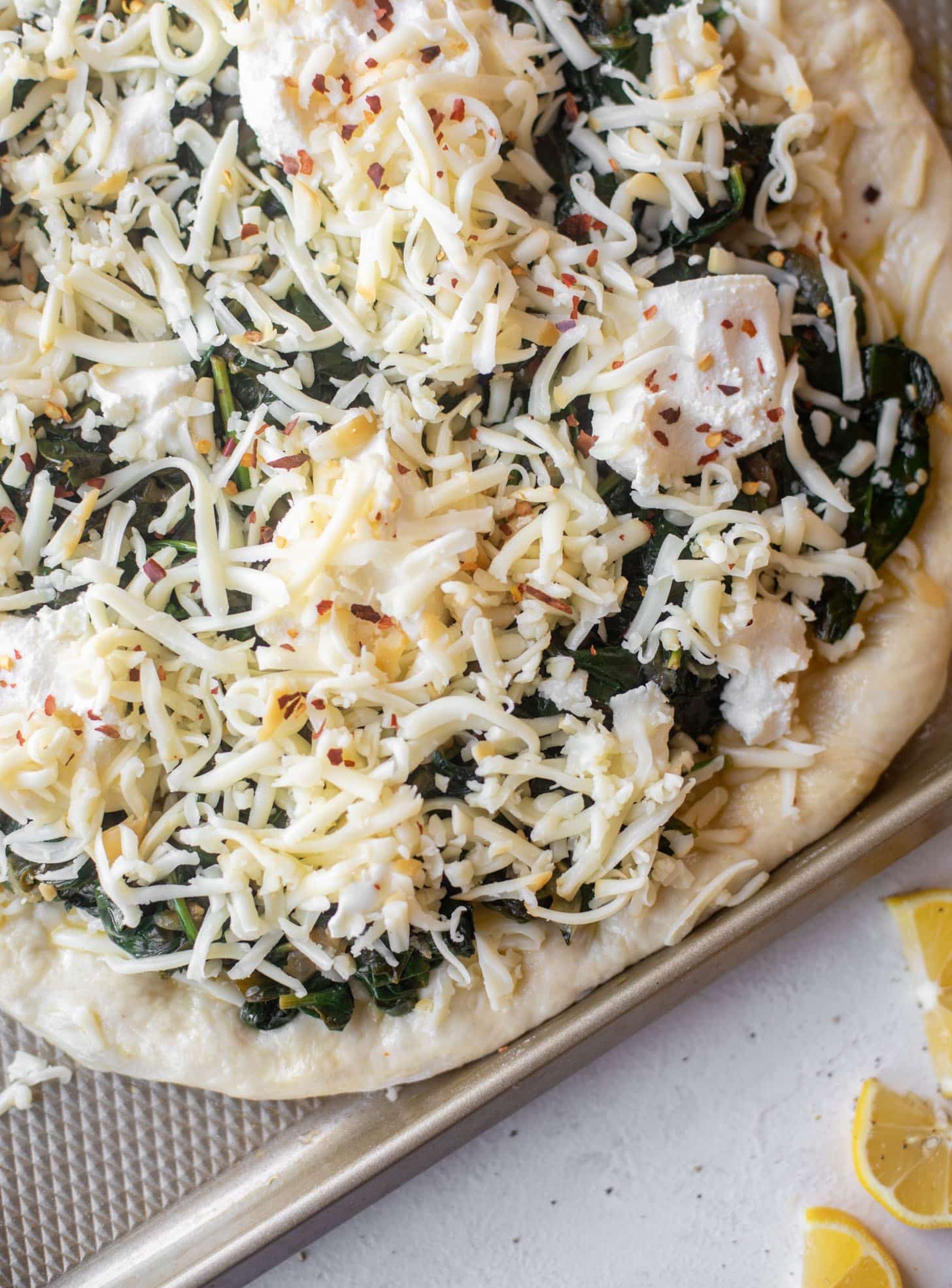 smoked mozzarella spinach pizza ready for the oven