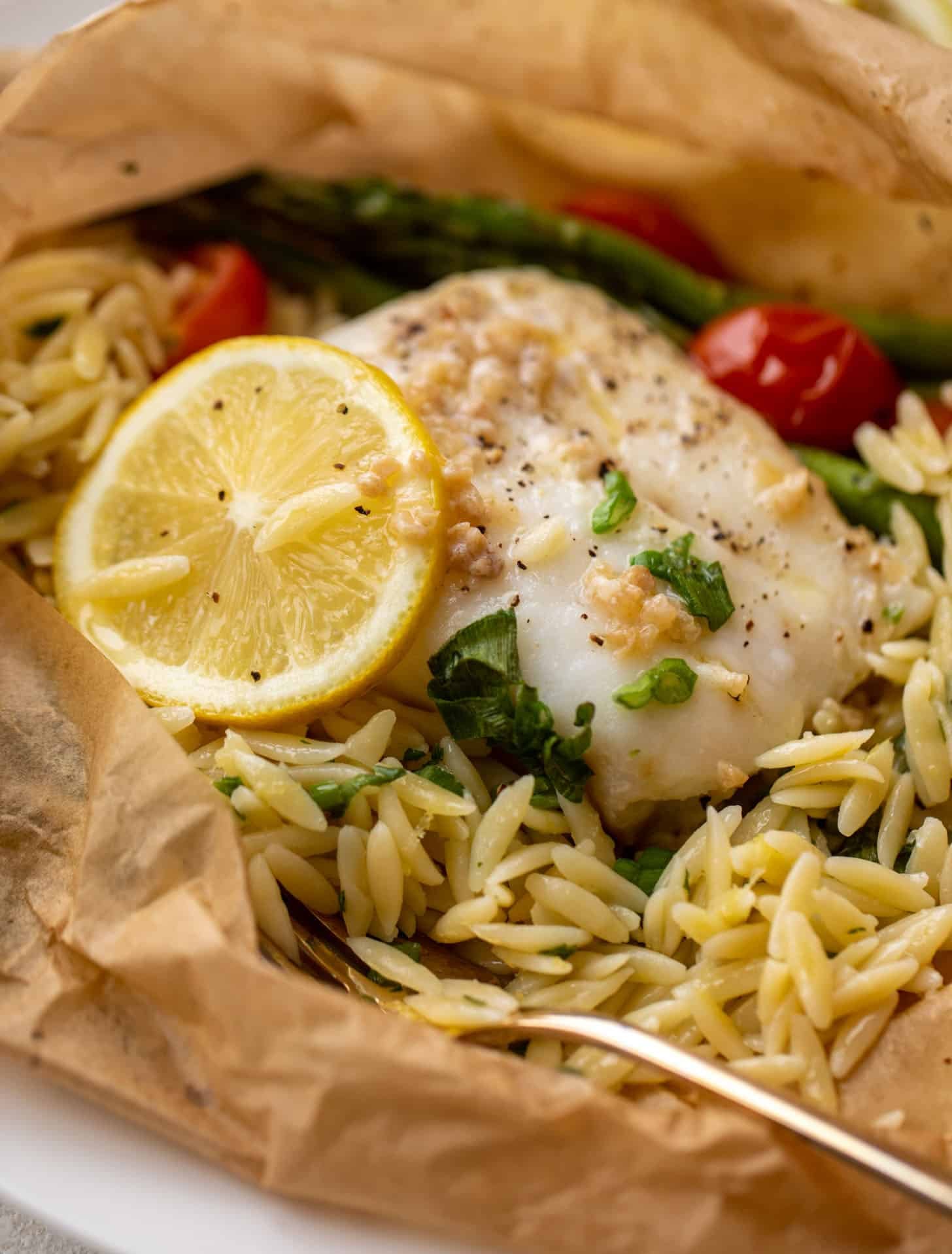 lemon garlic butter orzo and fish in parchment packet