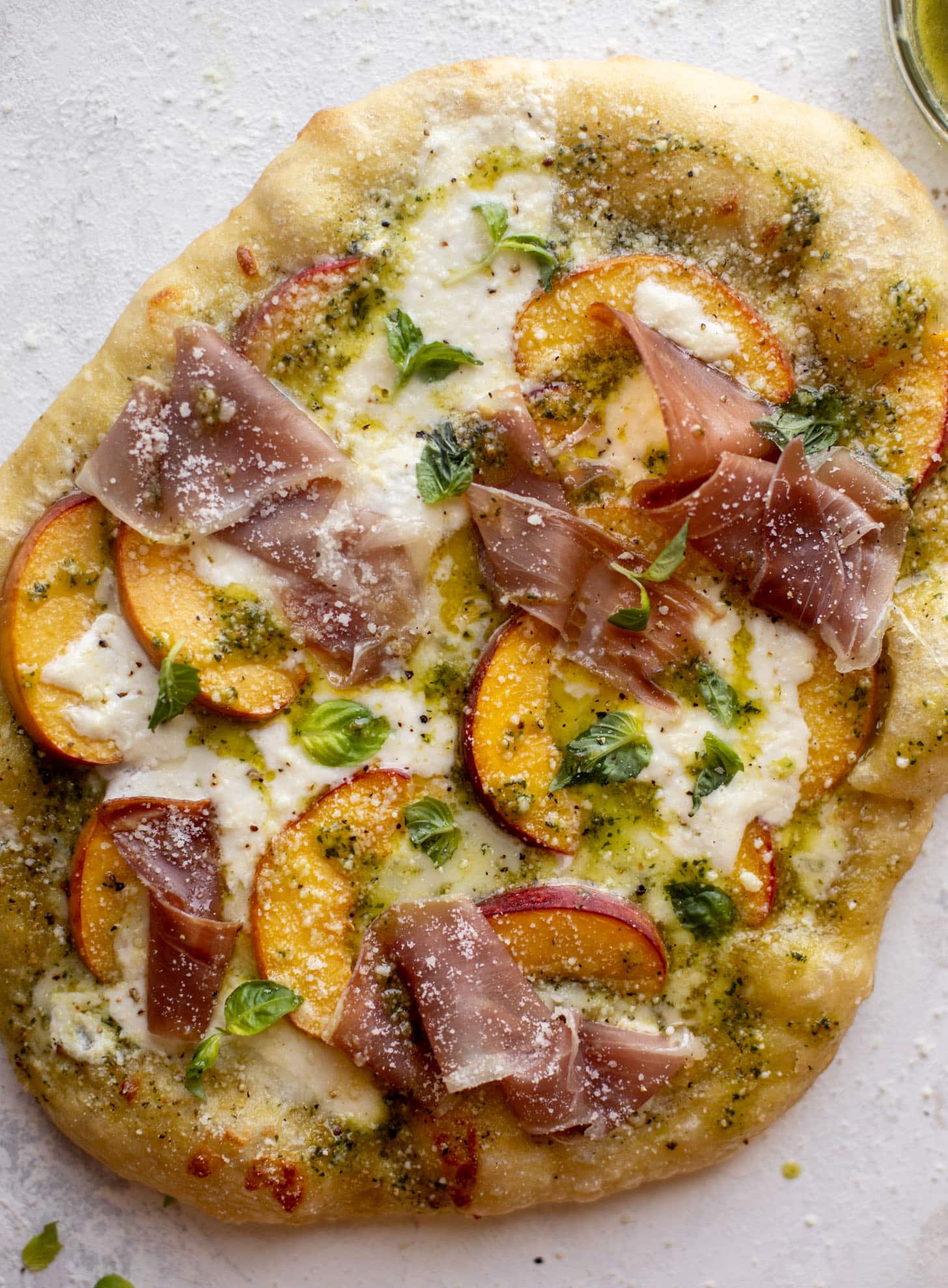 pesto peach pizza with prosciutto and burrata
