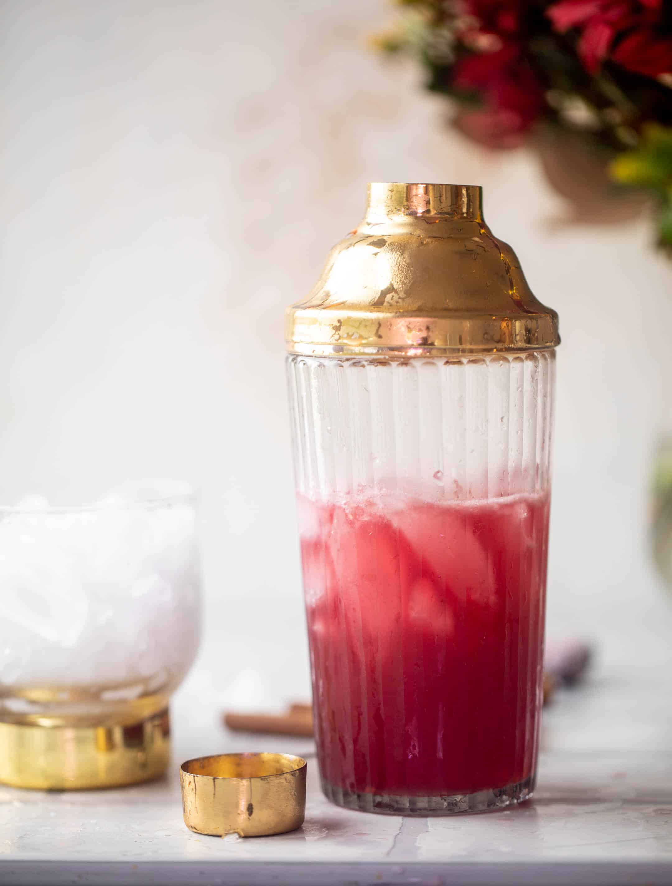 cranberry cinnamon whiskey sour in a shaker cup